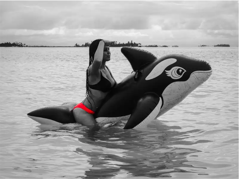 Schwimmerin mit Orca-Inflatable im Wasser vor San Blas Inseln.