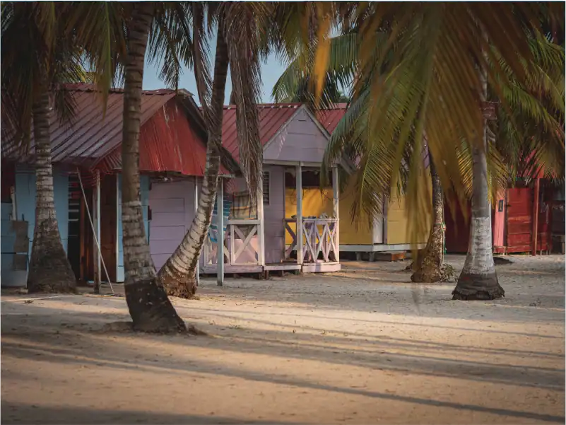 Bunte Strandhütten auf den San Blas Inseln, Panama, umgeben von Palmen.