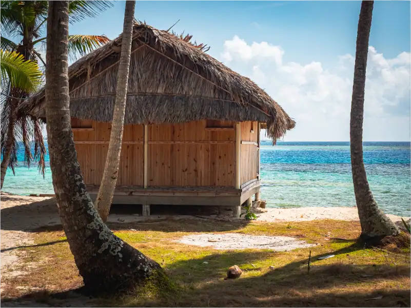 Bunte Strandhütten auf den San Blas Inseln, Panama, umgeben von Palmen.