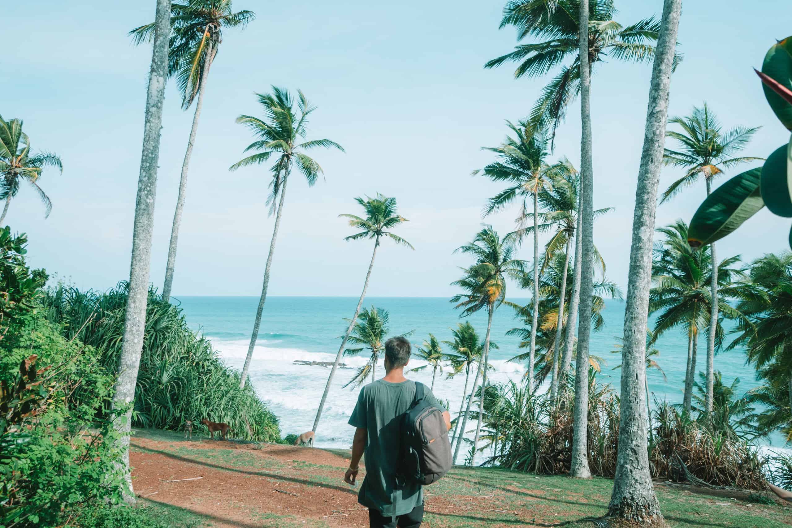 Reisender auf Pfad durch Palmen an den San Blas Inseln, Panama.
