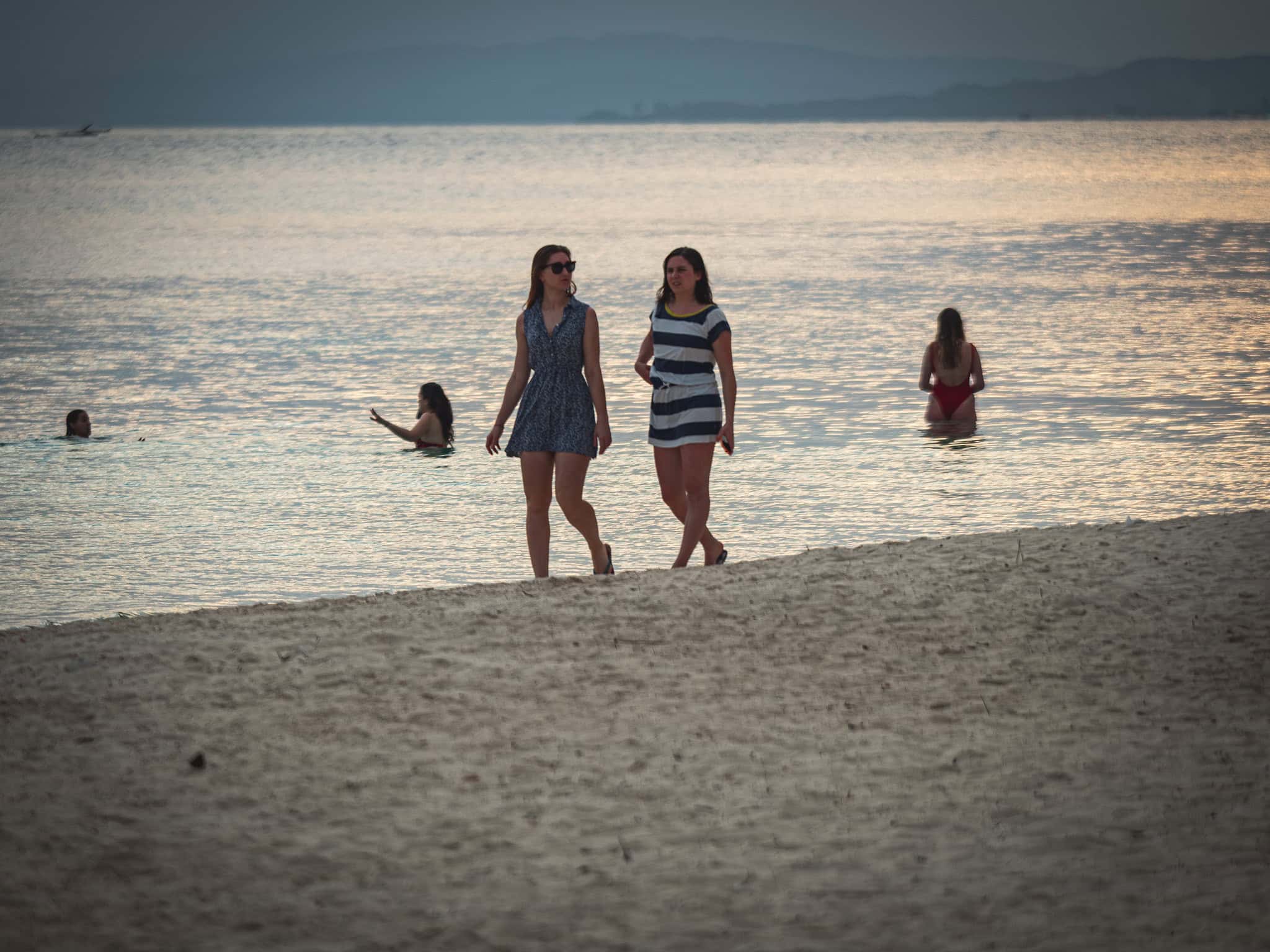 Zwei Frauen spazieren am Strand der San Blas Inseln in Panama.