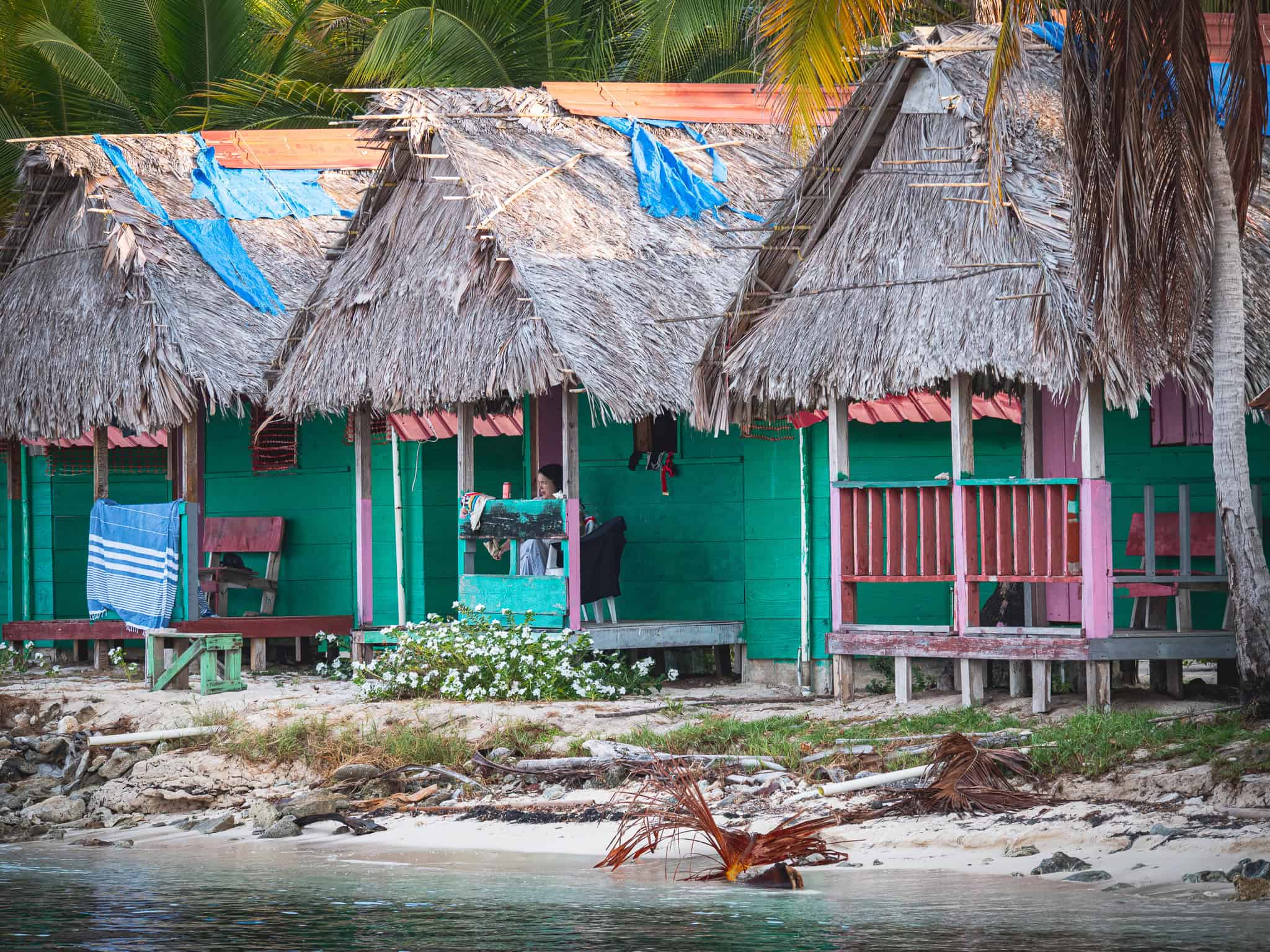 Traditionelle Hütten auf den San Blas Inseln, Panama, mit Palmen im Hintergrund.