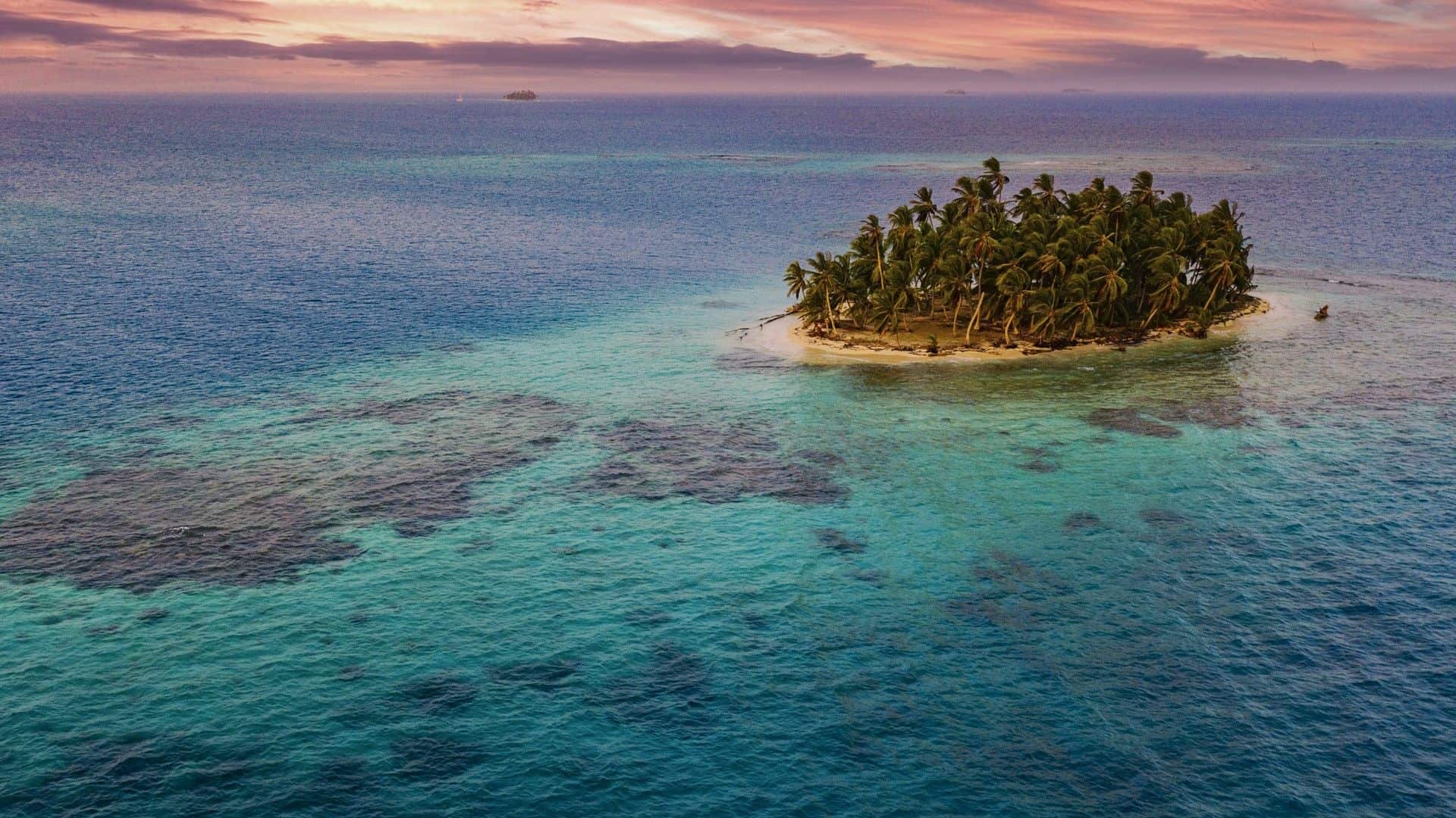 Kleines Inselparadies in Guna Yala, Panama, mit Palmen und türkisfarbenem Wasser.