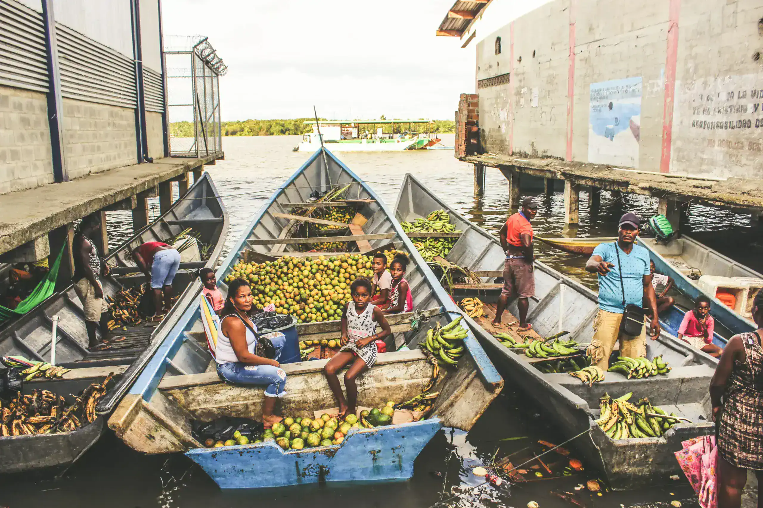 Menschen laden Früchte in Boote im Hafen von Guna Yala, Panama.
